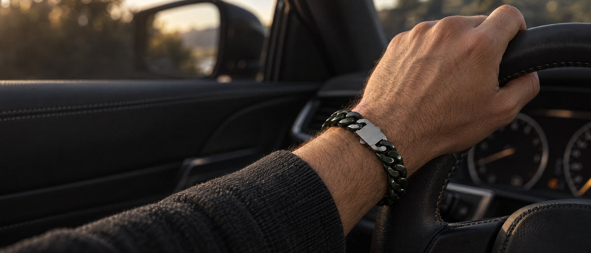 Dark green jade Cuban link bracelet on a wrist, hand on a steering wheel