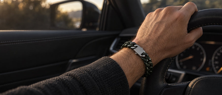 Dark green jade Cuban link bracelet on a wrist, hand on a steering wheel