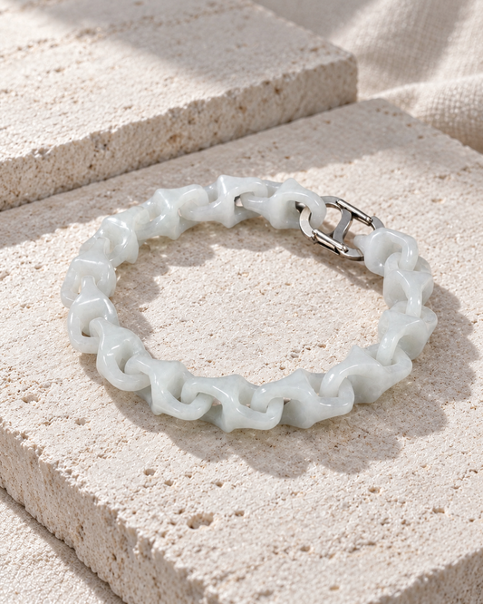 Dragon Spine Bracelet In White Jade on flat pale stone