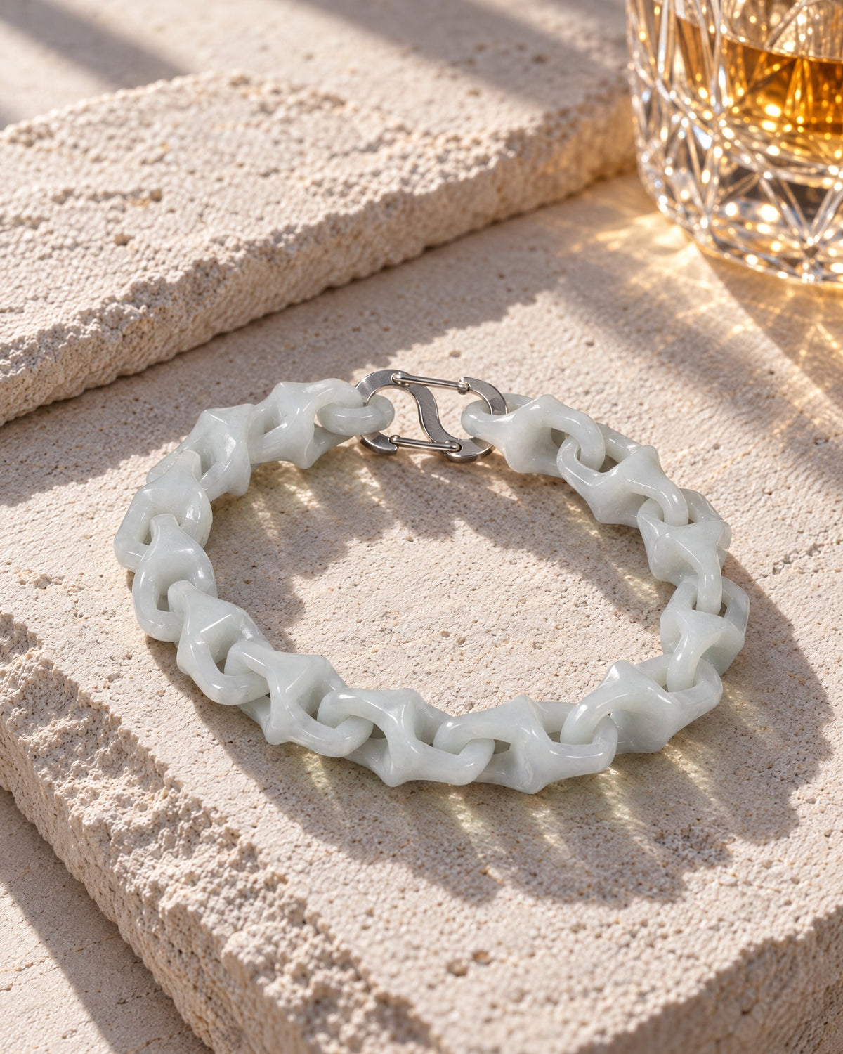 Dragon Spine Bracelet In White Jade on pale limestone in warm sunlight