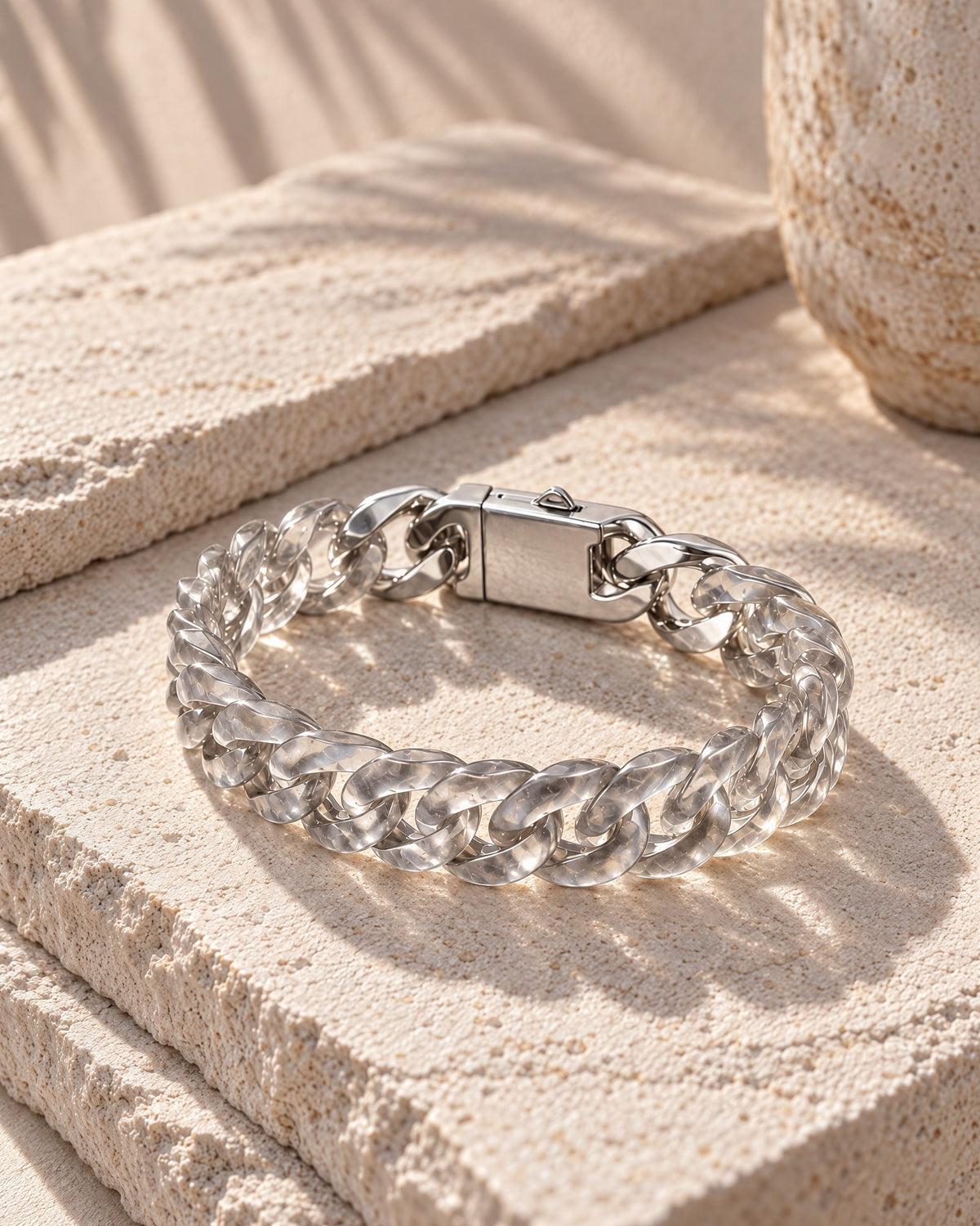 Classic Cuban Link Chain Bracelet In Clear Quartz resting on its side on pale stone in soft daylight