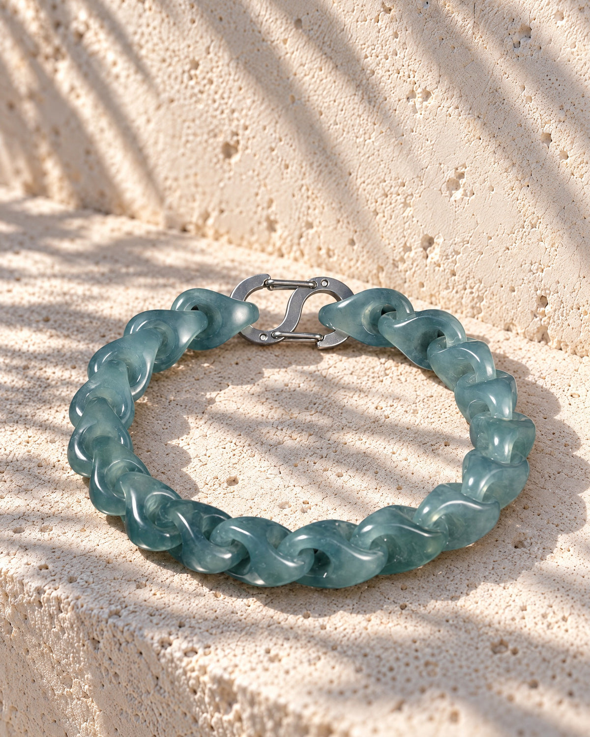 Single Piece Carved Dragon Spine Cable Chain Bracelet In Mayan Jade on pale limestone in warm sunlight