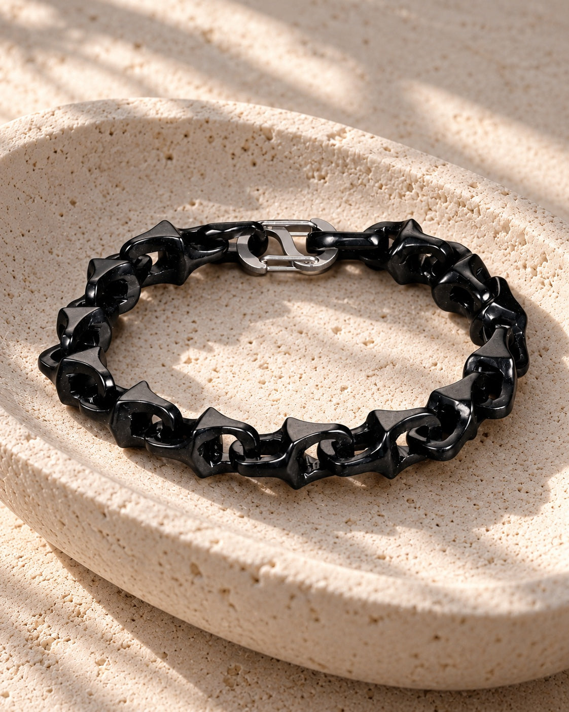 Dragon Spine Bracelet In Black Mayan Jade on white stone: Shallow stone dish