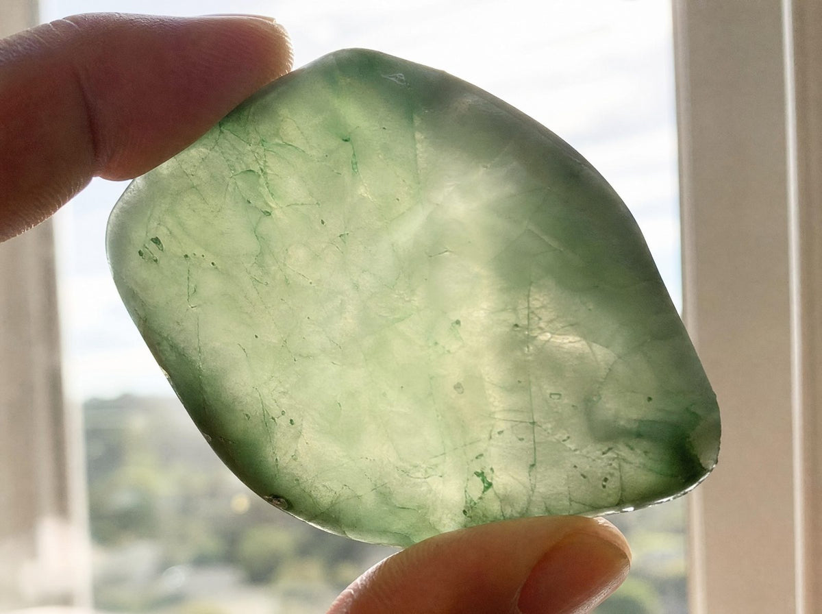 Natural green jade held up to window light